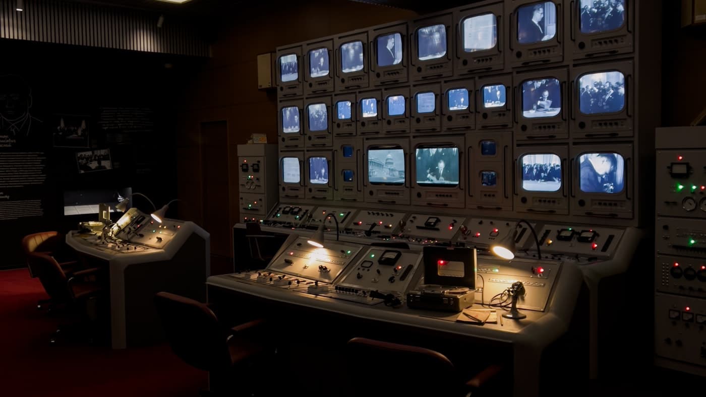A control room of monitors and indicator lights — the visible authority layer most CX stacks are missing